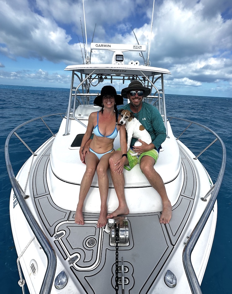 couple sitting with siba on the bow of the boat